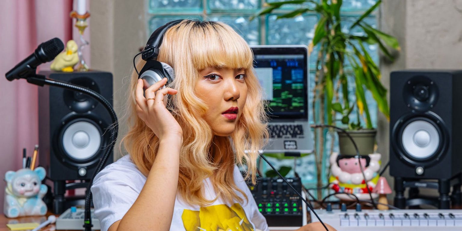 Woman at her home studio, with headphones on